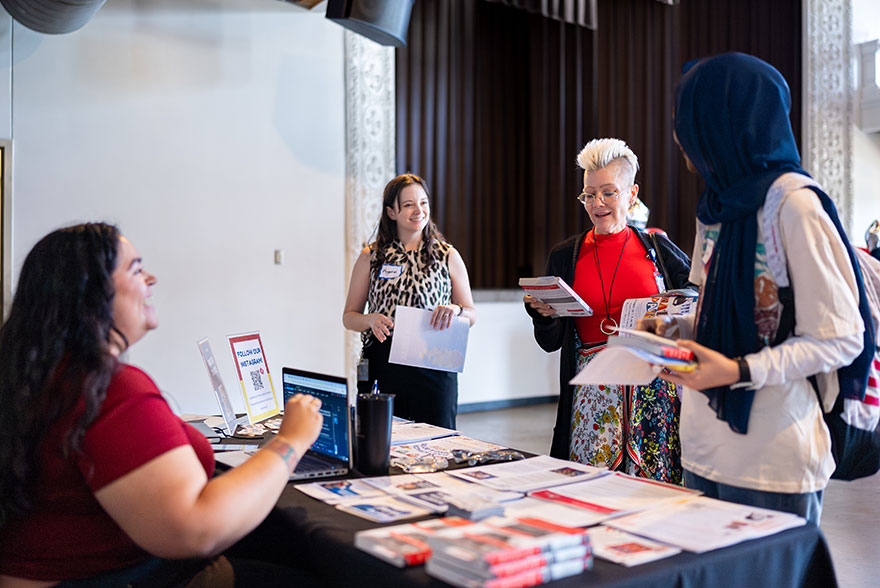 New employees visit table at welcome event to get information about MSU Denver.