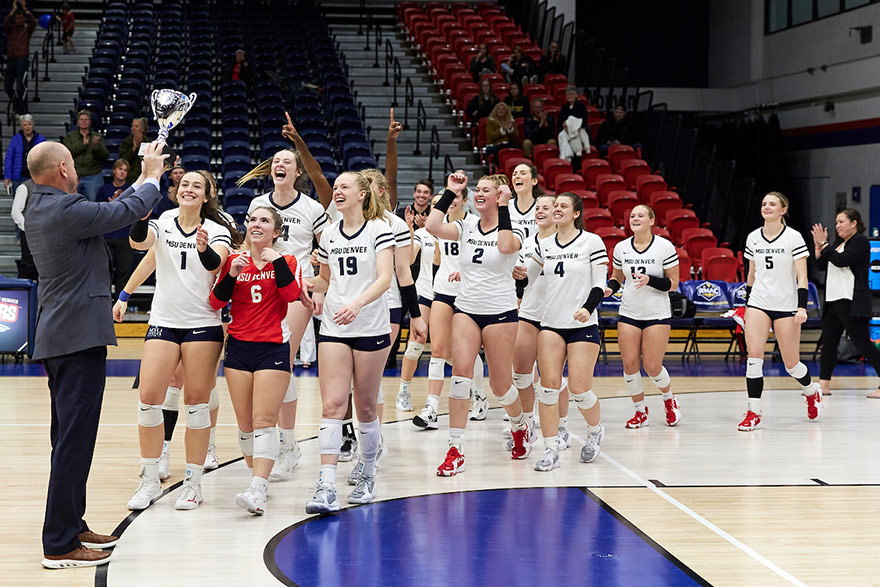 Roadrunners Volleyball team celebrates and receives conference championship trophy.