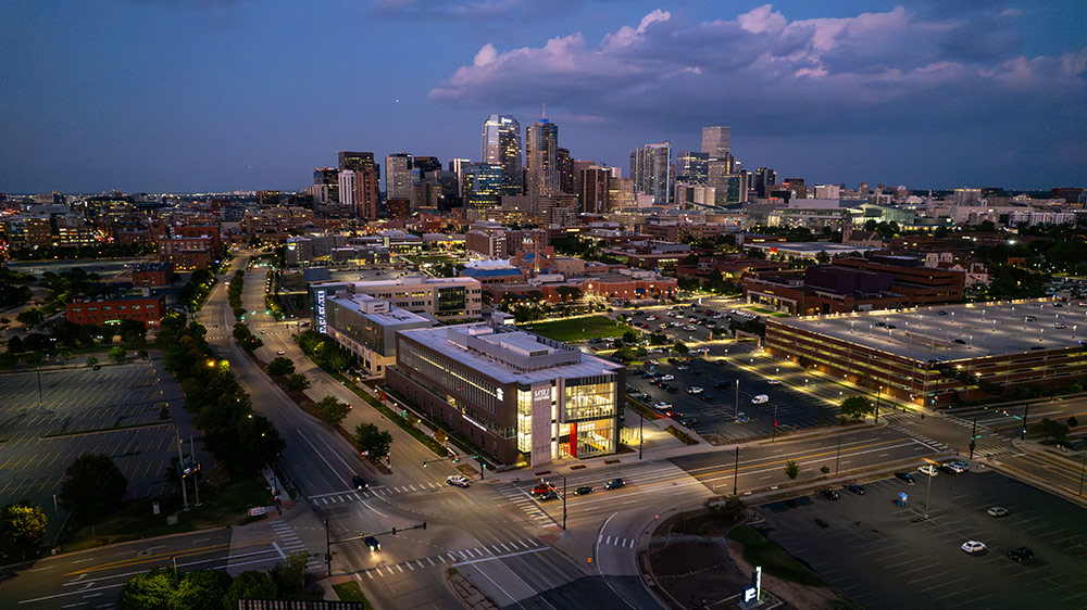 Nighttime aerial shot of the Auraria Campus with the Denver skyline in the backdrop.