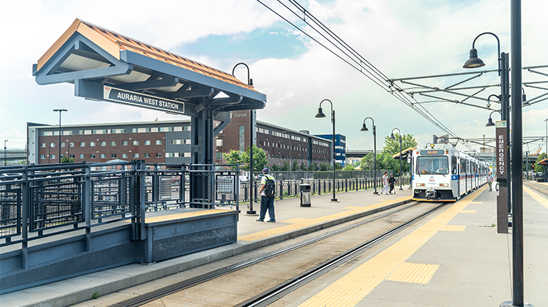 A train arrives at the Auraria West Station, shown from the perspective next to the track.
